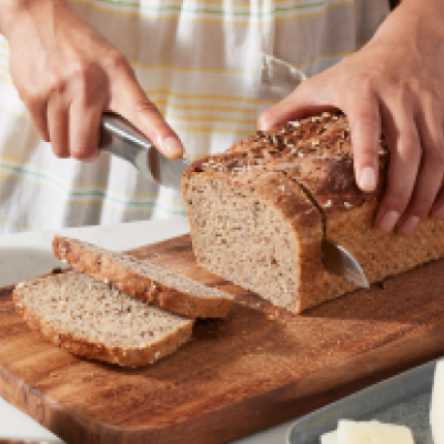 Person slicing homemade sandwich bread