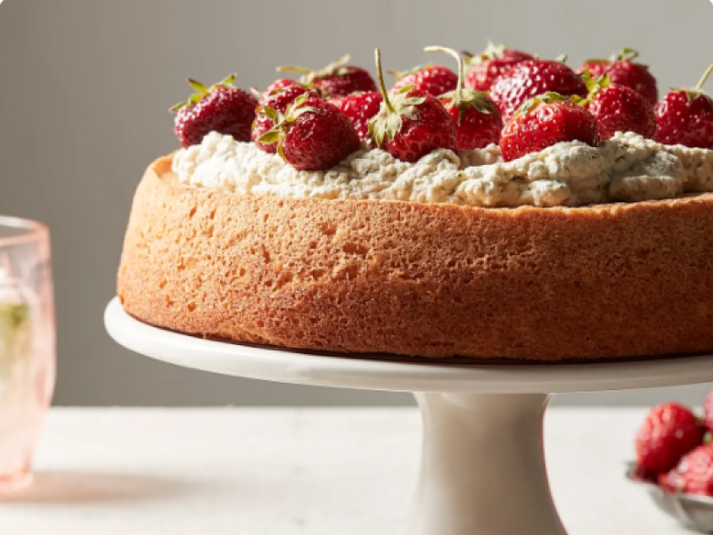 Chiffon cake with whipped cream and strawberries on cake stand
