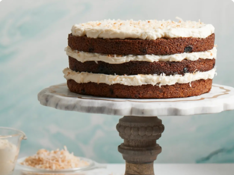 Three-layer carrot cake with cream cheese frosting on cake stand