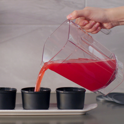 Pitcher of frozen mixture being poured into ice mold
