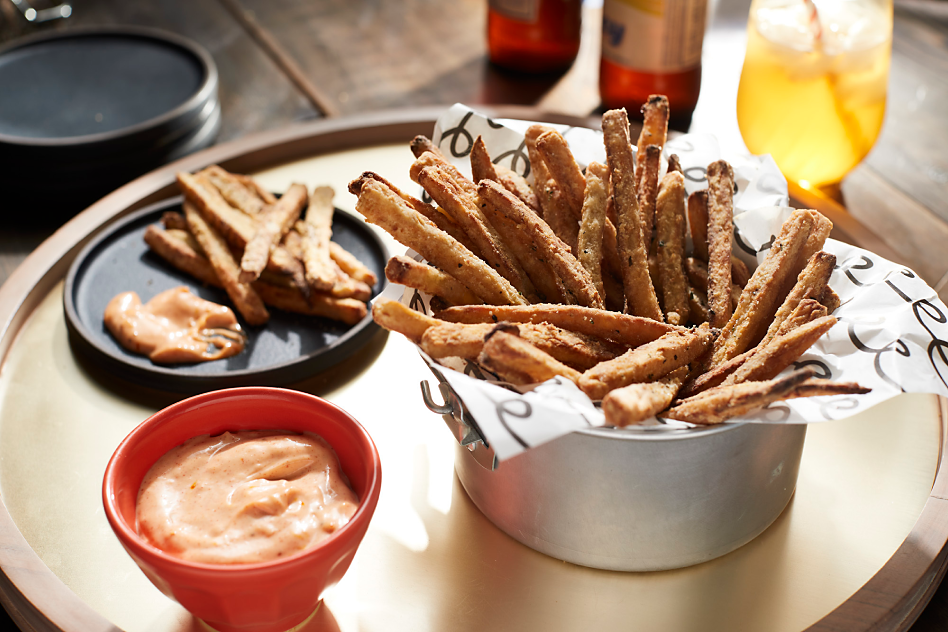 Homemade air-fried french fries and dipping sauce sitting on tray.