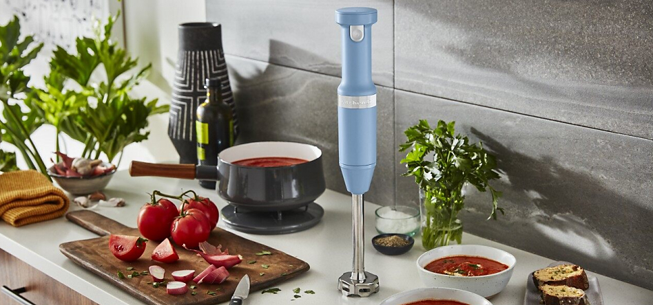 Blue Velvet cordless hand blender on countertop with tomato soup