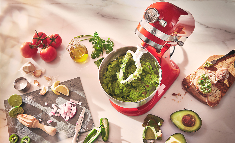 Red stand mixer from above with guacamole and ingredients