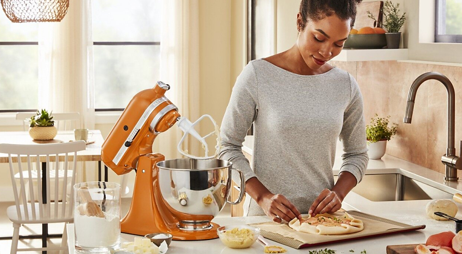 Woman making a galette next to a KitchenAid® stand mixer in Honey