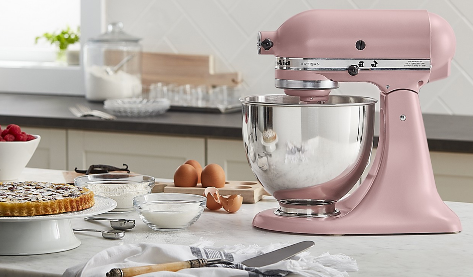 Pink Artisan® Series Stand Mixer on a countertop surrounded by cooking ingredients