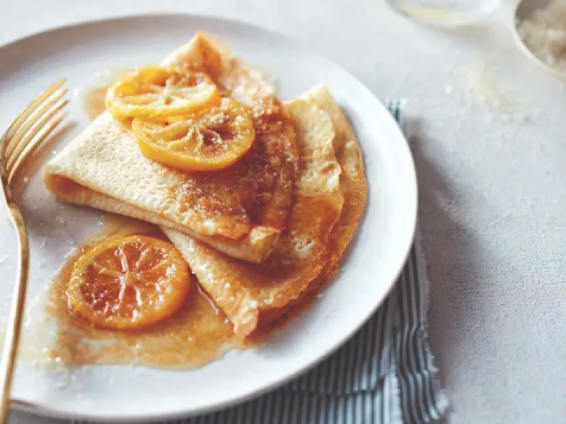 A plate of crepes with lemon and sugar.