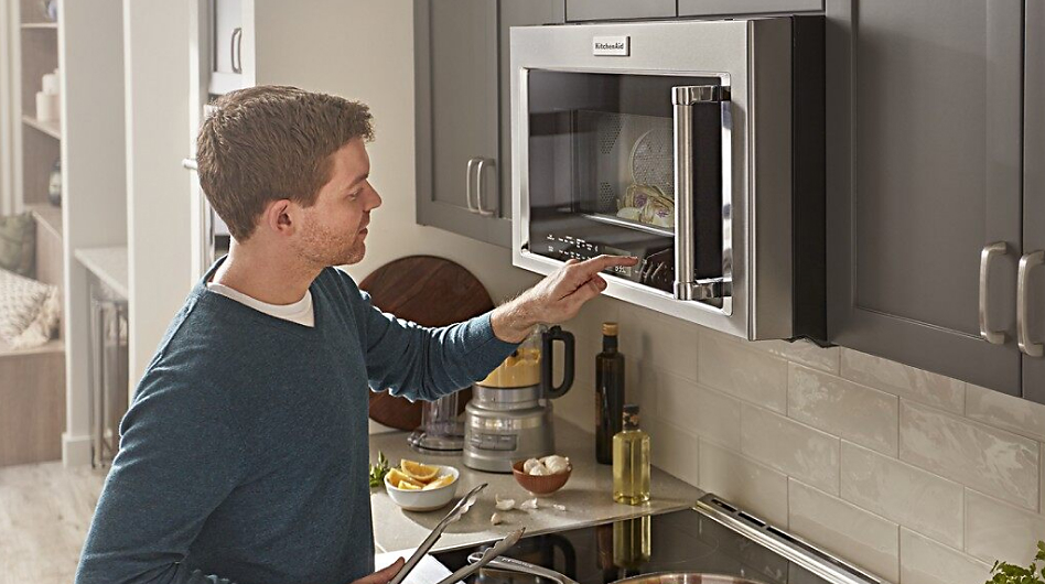 Man standing in front of an over-the-range microwave