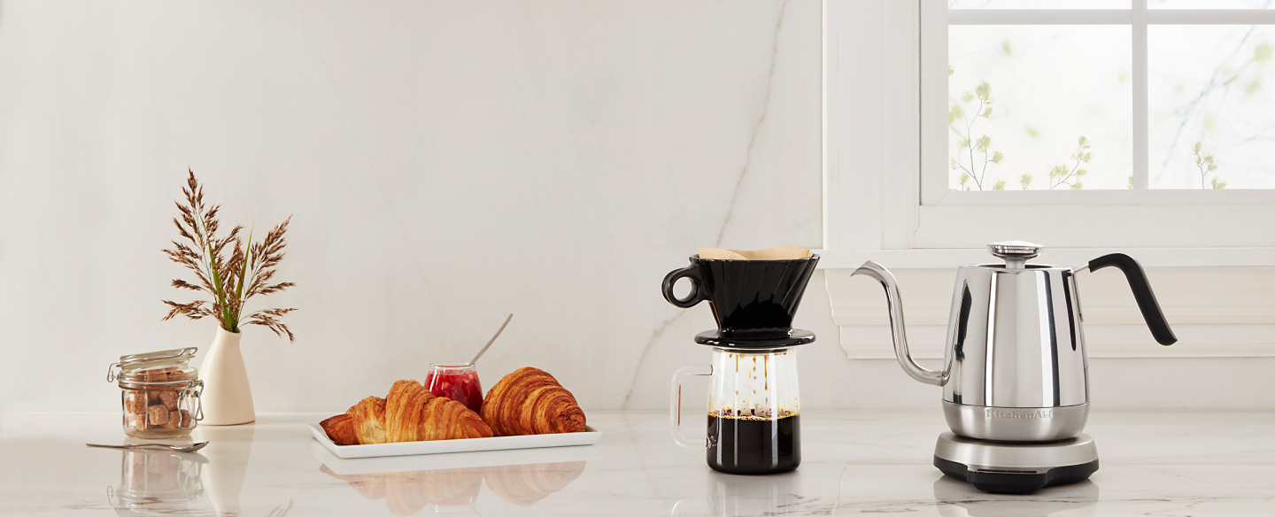 KitchenAid® electric goose-necked kettle next to a coffee and pastries