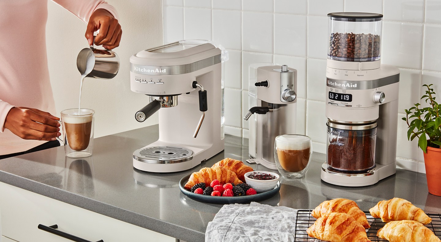 Coffee bar with a white KitchenAid® Espresso Maker, Milk Frother Attachment and Burr Grinder