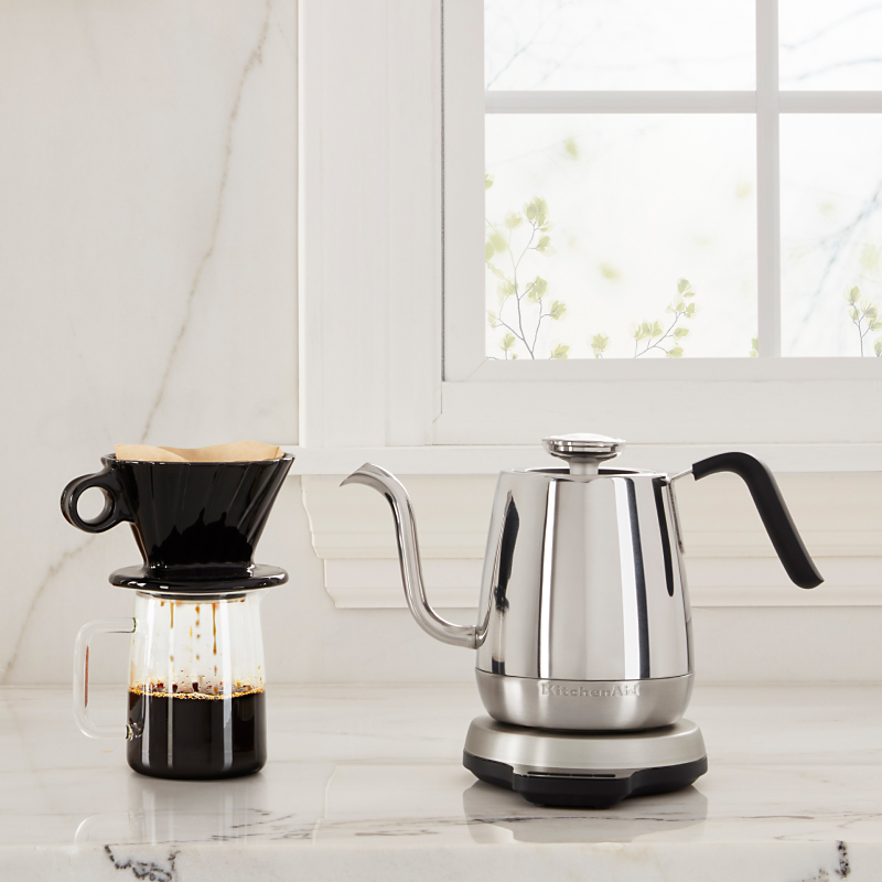 KitchenAid® electric goose-necked kettle next to a coffee and pastries