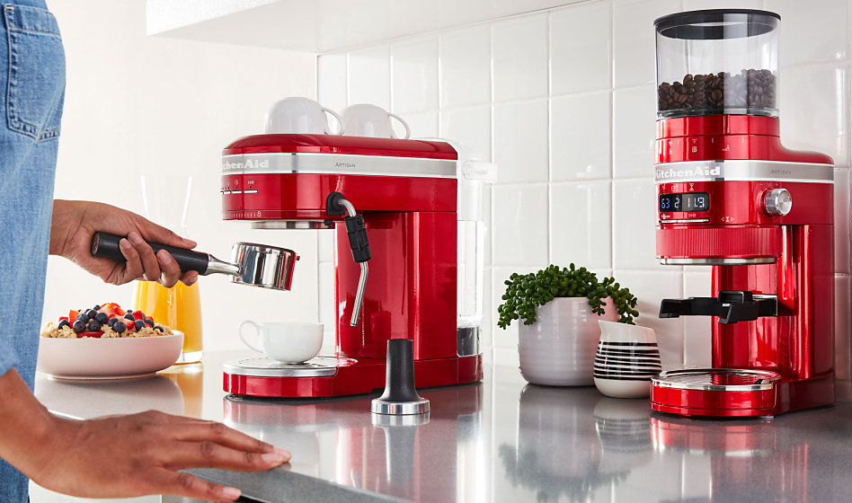 Woman making espresso using a red KitchenAid® espresso machine