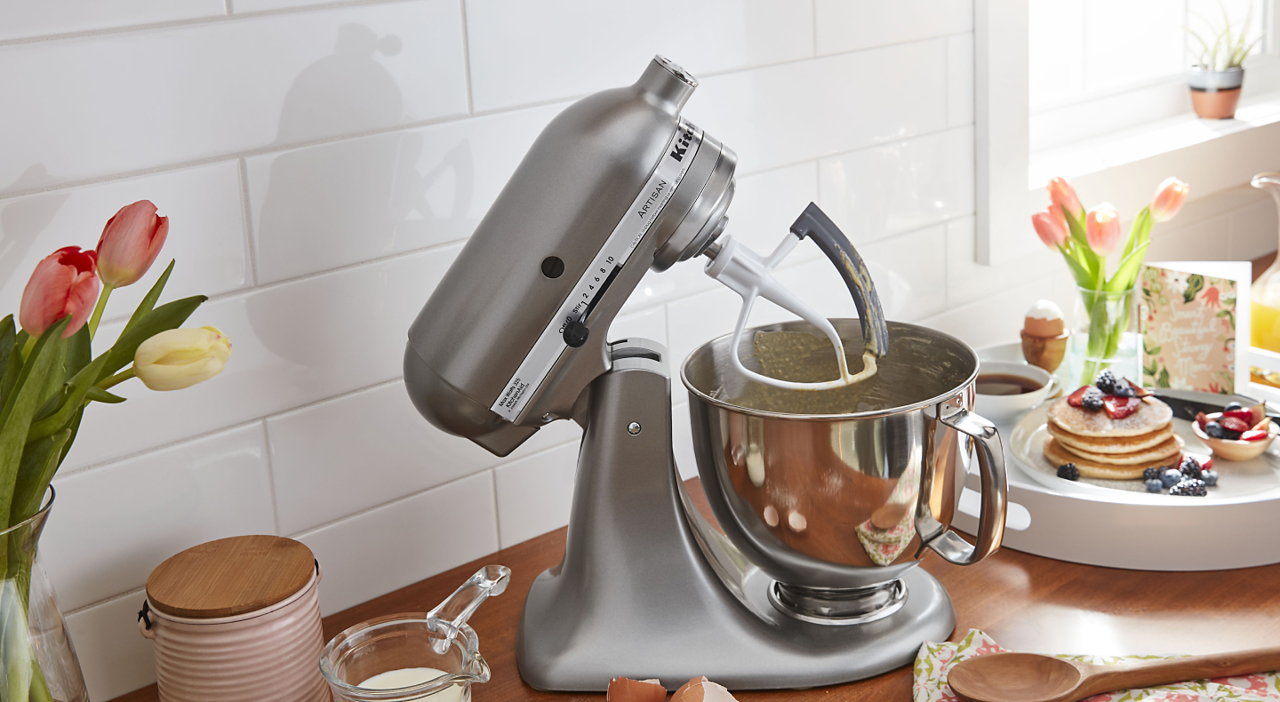 KitchenAid® stand mixer with flex edge beater next to pancakes