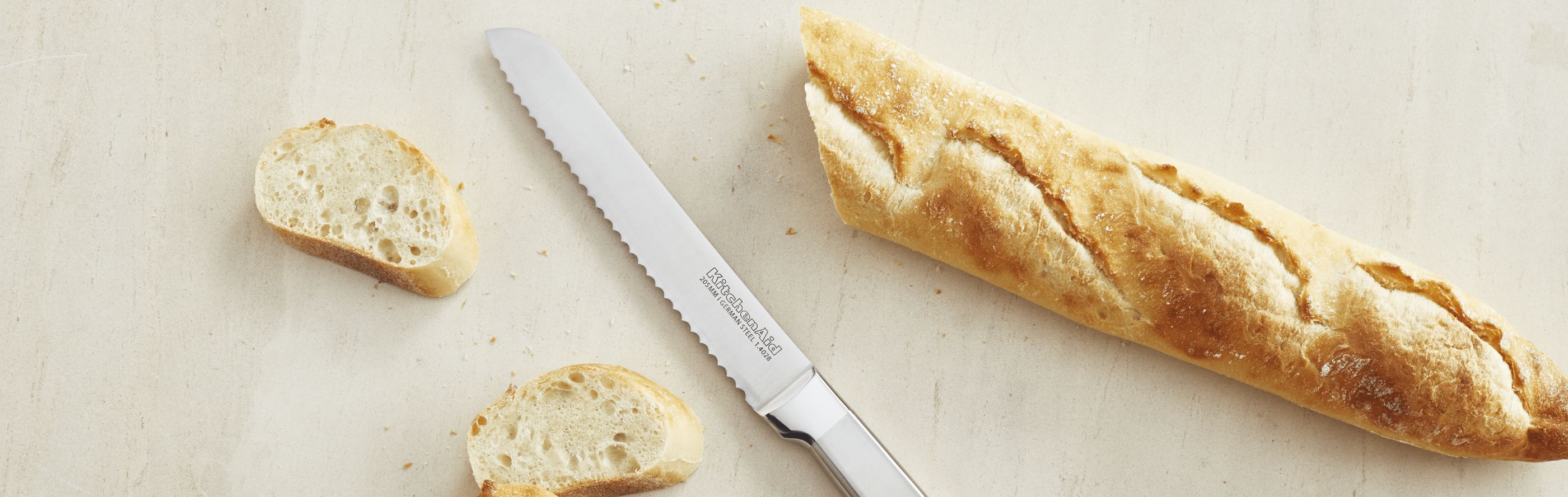 A KitchenAid® knife next to a loaf of bread.