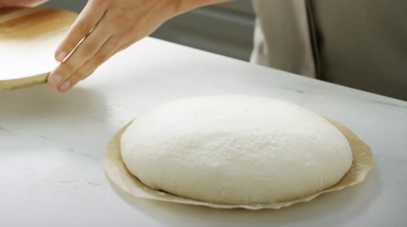 A mound of dough resting on parchment paper.