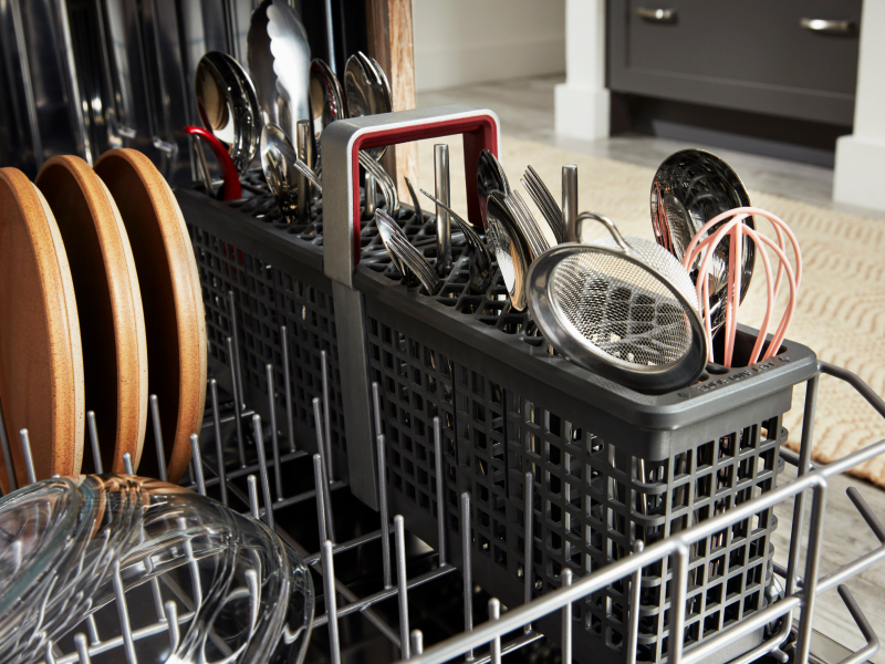 Open dishwasher filled with dishes and utensils