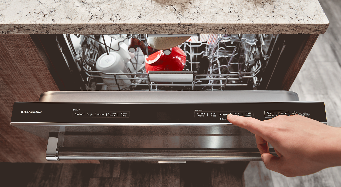 Person pressing a button on a dishwasher
