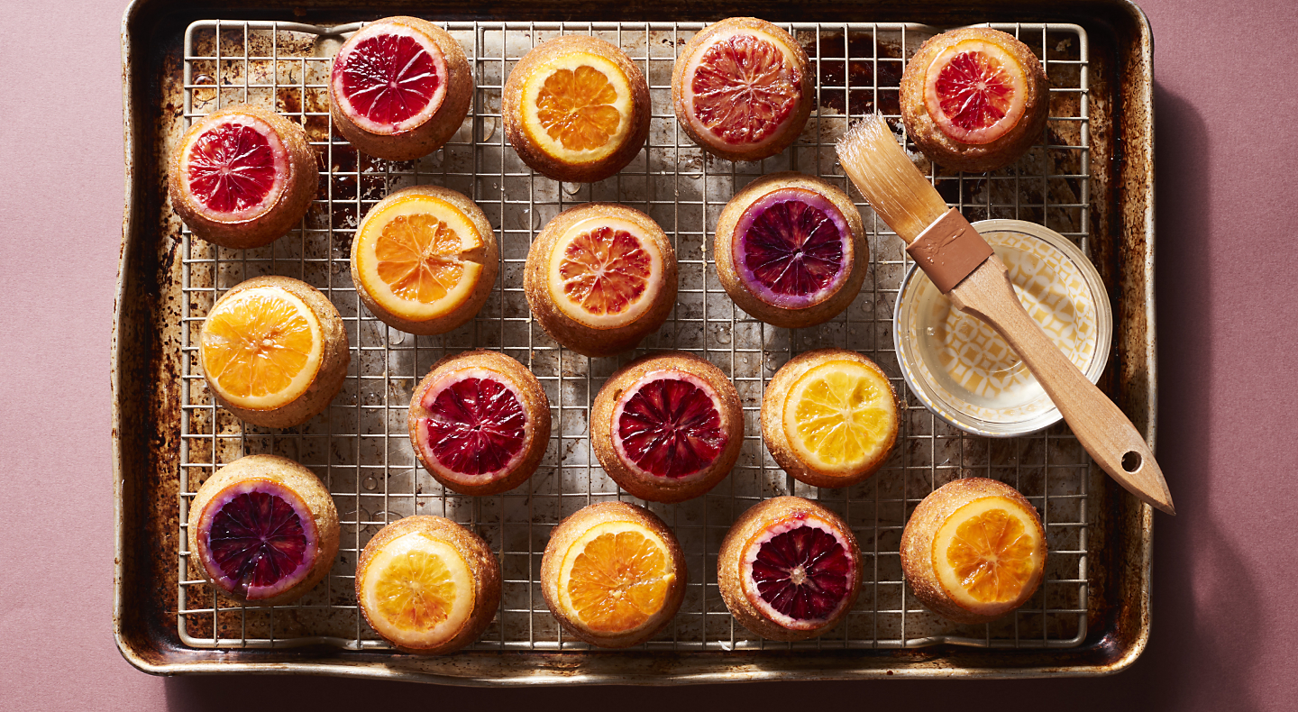 Citrus topped baked goods on cooking rack above cookie sheet