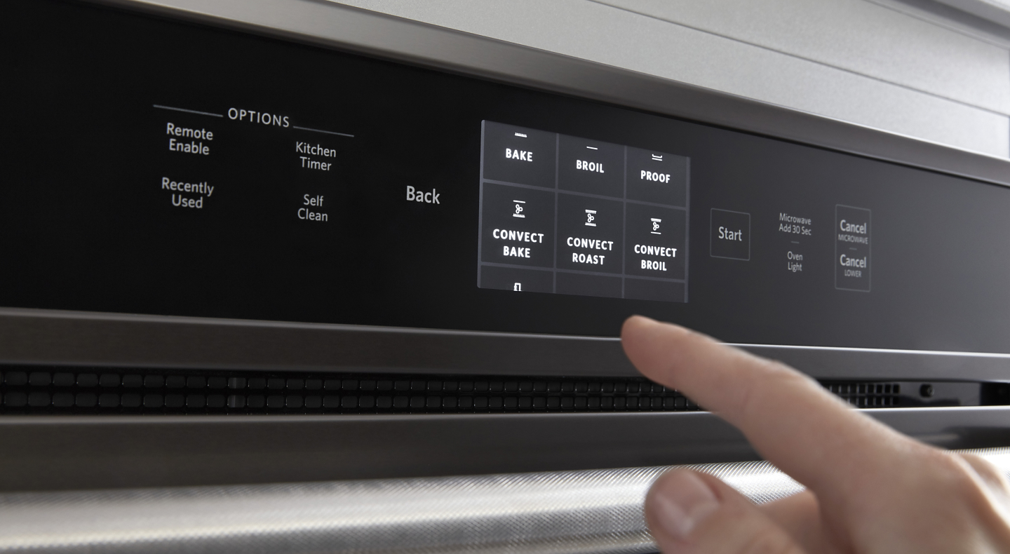 Person selecting settings on oven control panel