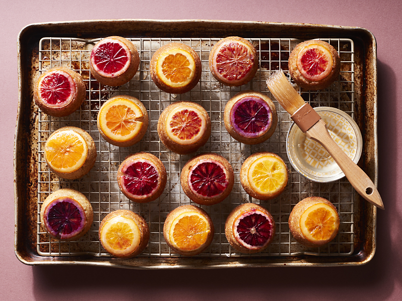 Citrus topped baked goods on cooking rack above cookie sheet