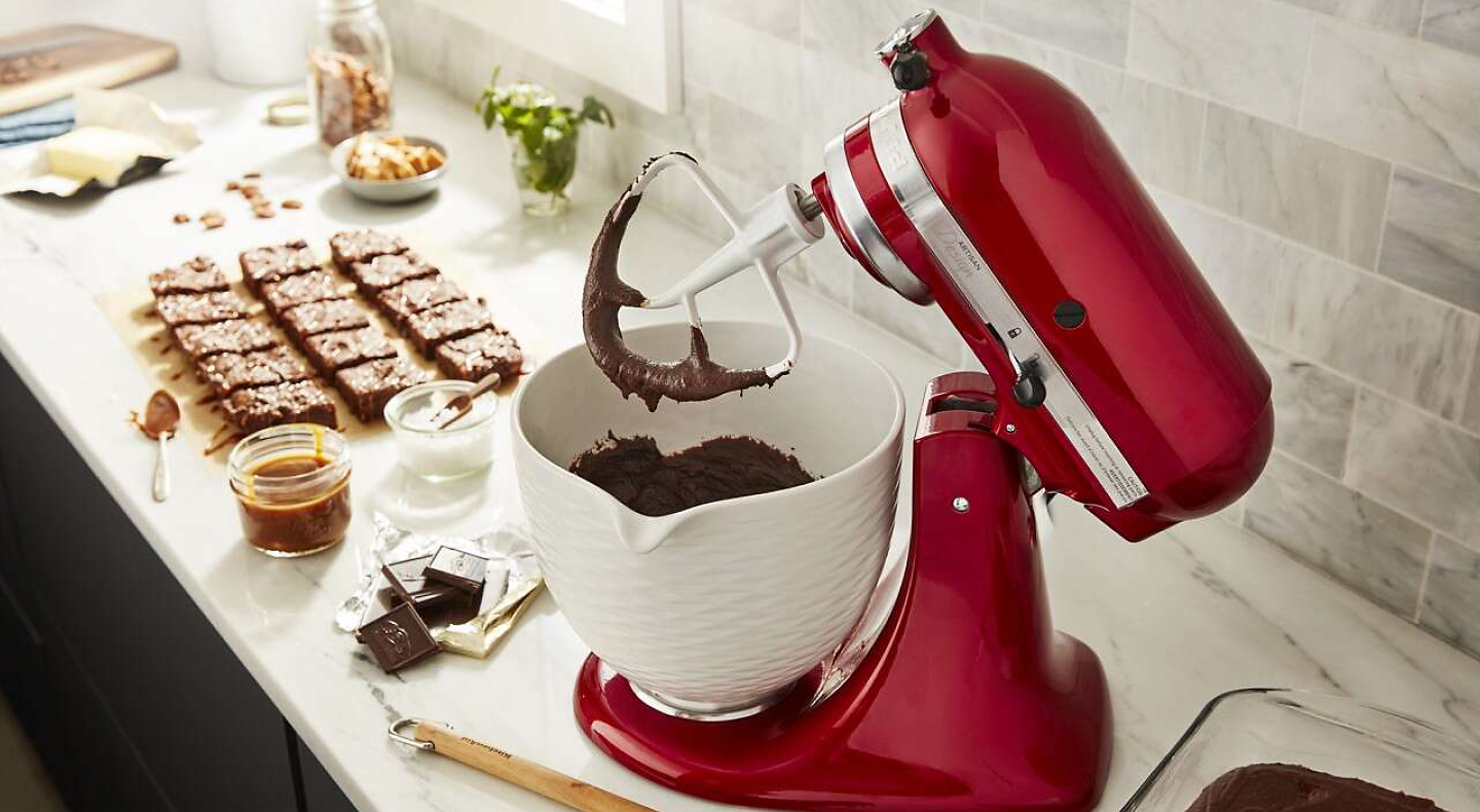 Red KitchenAid® stand mixer with white mixer bowl full of brownie batter