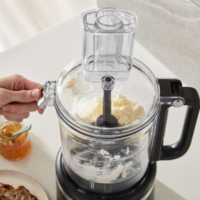 Person processing ingredients in a black KitchenAid® food processor