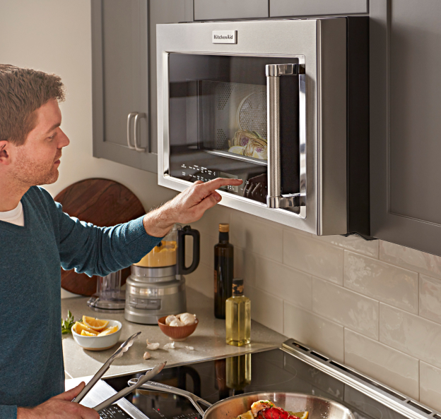 Man using an over-the-range microwave 