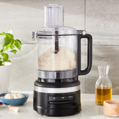 A KitchenAid® food processor with flour in the bowl.