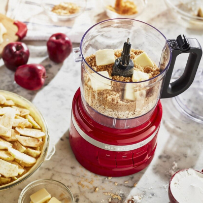 A KitchenAid® food processor with flour and butter in the bowl.