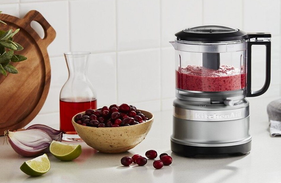 Food processor filled with a fruit purée on a counter
