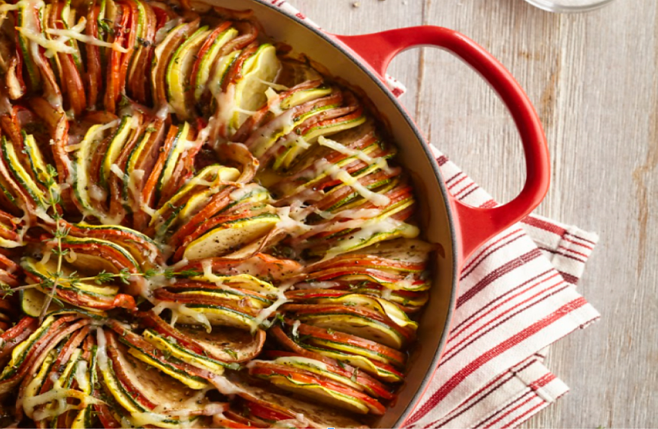 Baked ratatouille with sliced vegetables in a red dish