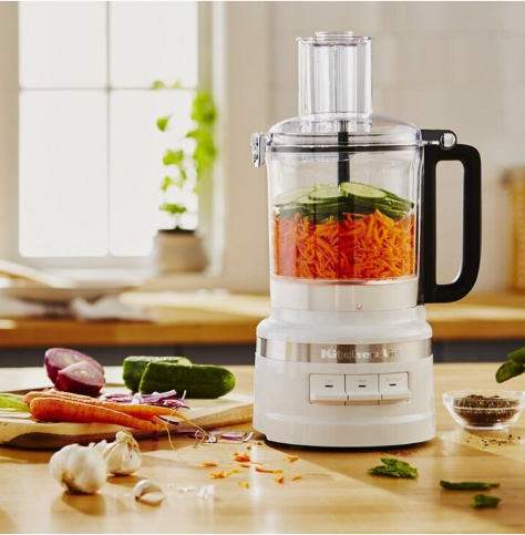 Food processor filled with carrots and cucumbers