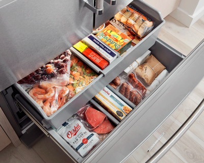 Open bottom freezer drawer full of food