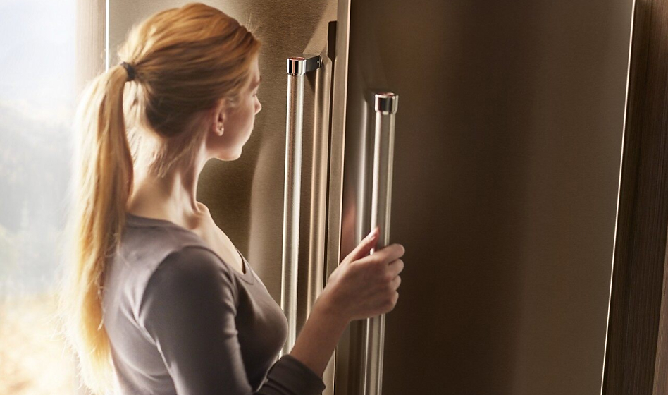Woman looking inside a side by side or French door refrigerator