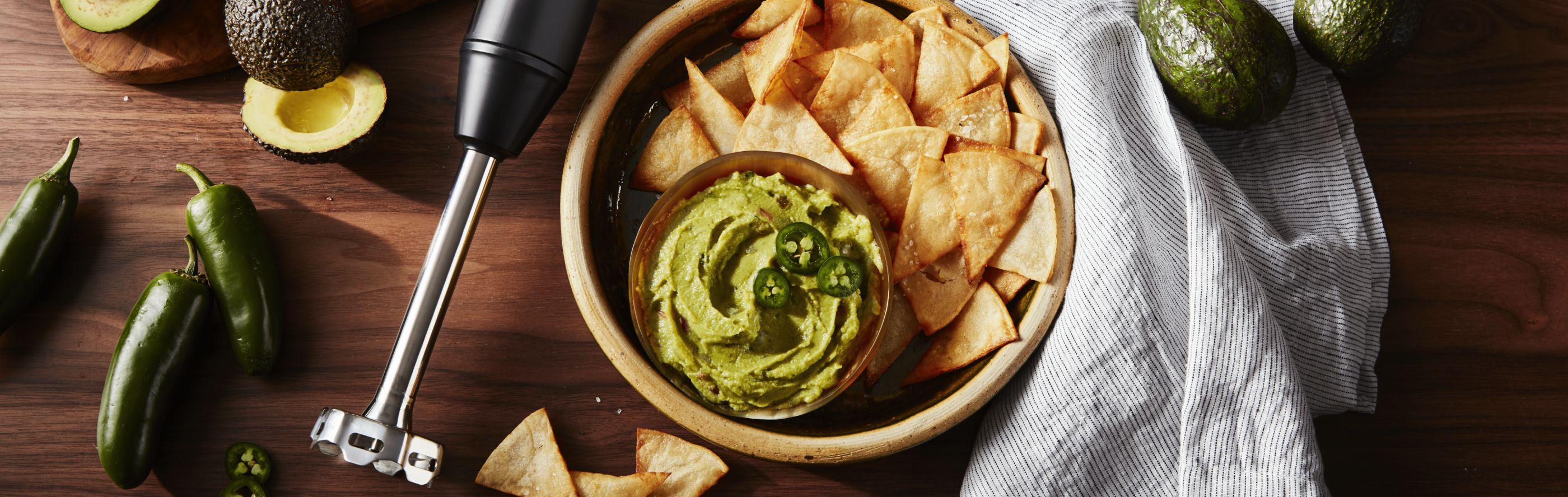 Guacamole and chips next to KitchenAid® hand blender