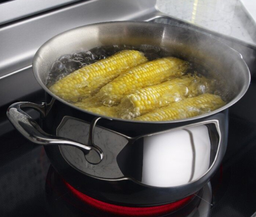 Corn on the cob boiling on an electric stove
