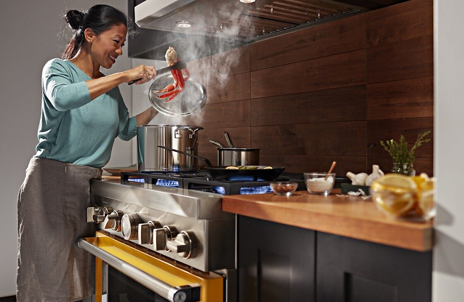 Woman cooking crab legs on a gas range