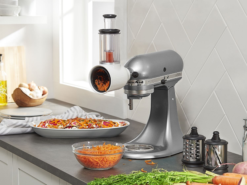 Silver KitchenAid® stand mixer with the Fresh Prep Slicer/Shredder Attachment shredding carrots