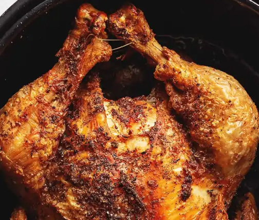 Whole roast chicken in an air fryer basket