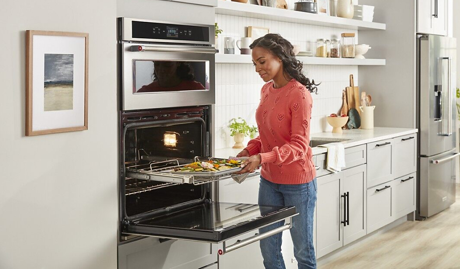 Woman placing baking sheet in the oven
