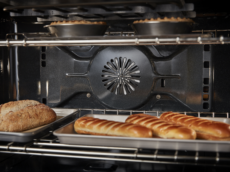 Bread and pies baking on multiple racks in convection oven