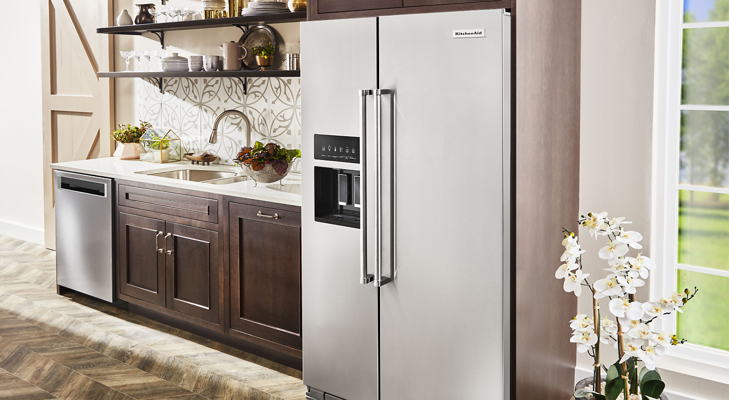 KitchenAid® side-by-side refrigerator in kitchen with brown cabinetry