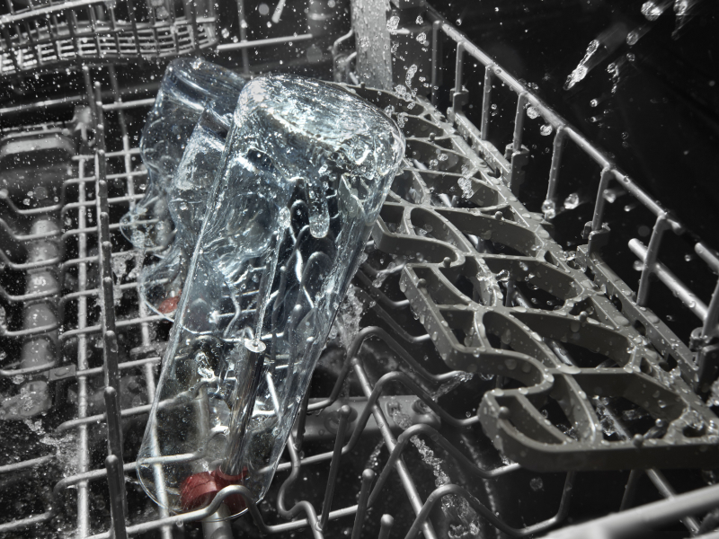 The top rack of a KitchenAid® dishwasher during a wash cycle.