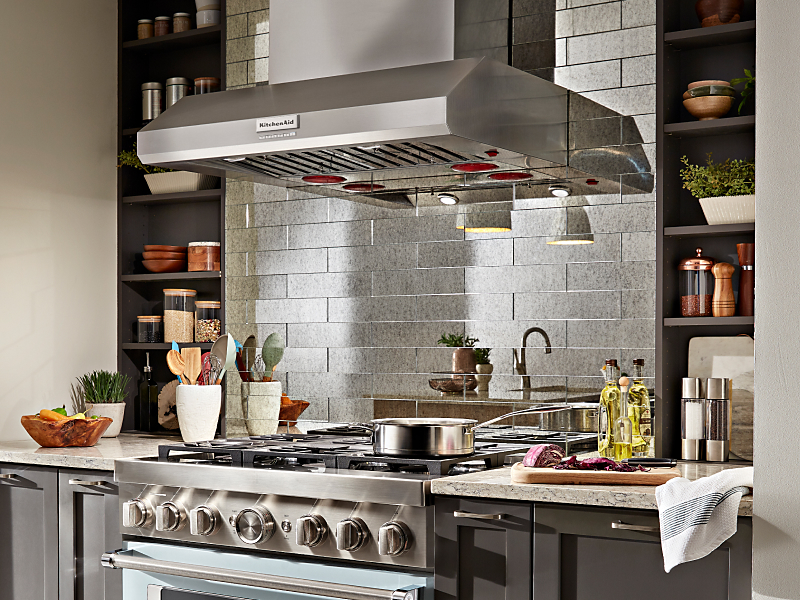KitchenAid® commercial range hood above gas stovetop with pot on top