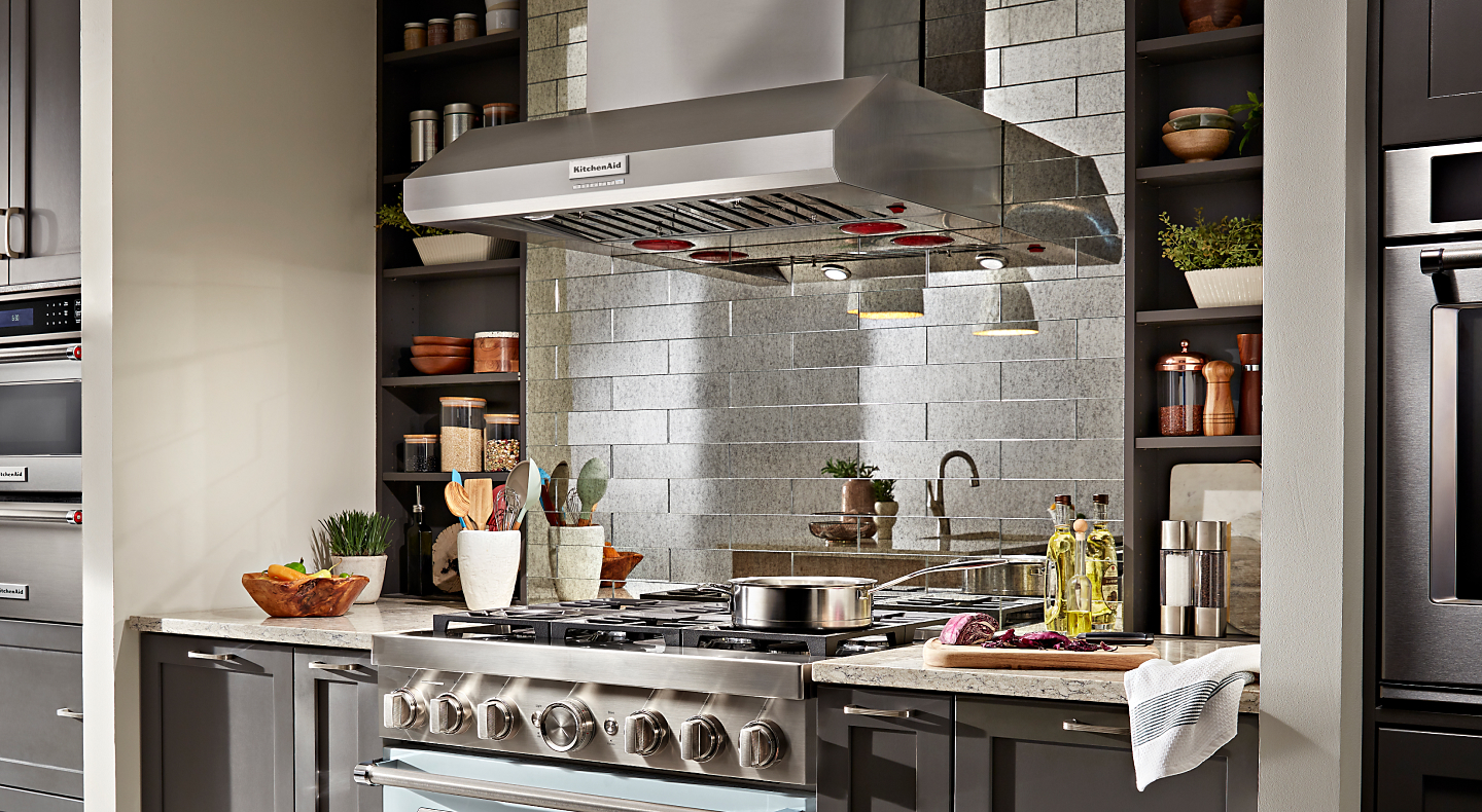 KitchenAid® commercial range hood above gas stovetop with pot on top
