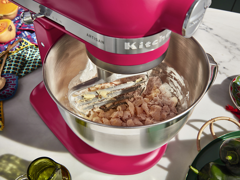 A red KitchenAid® stand mixer used to make dough