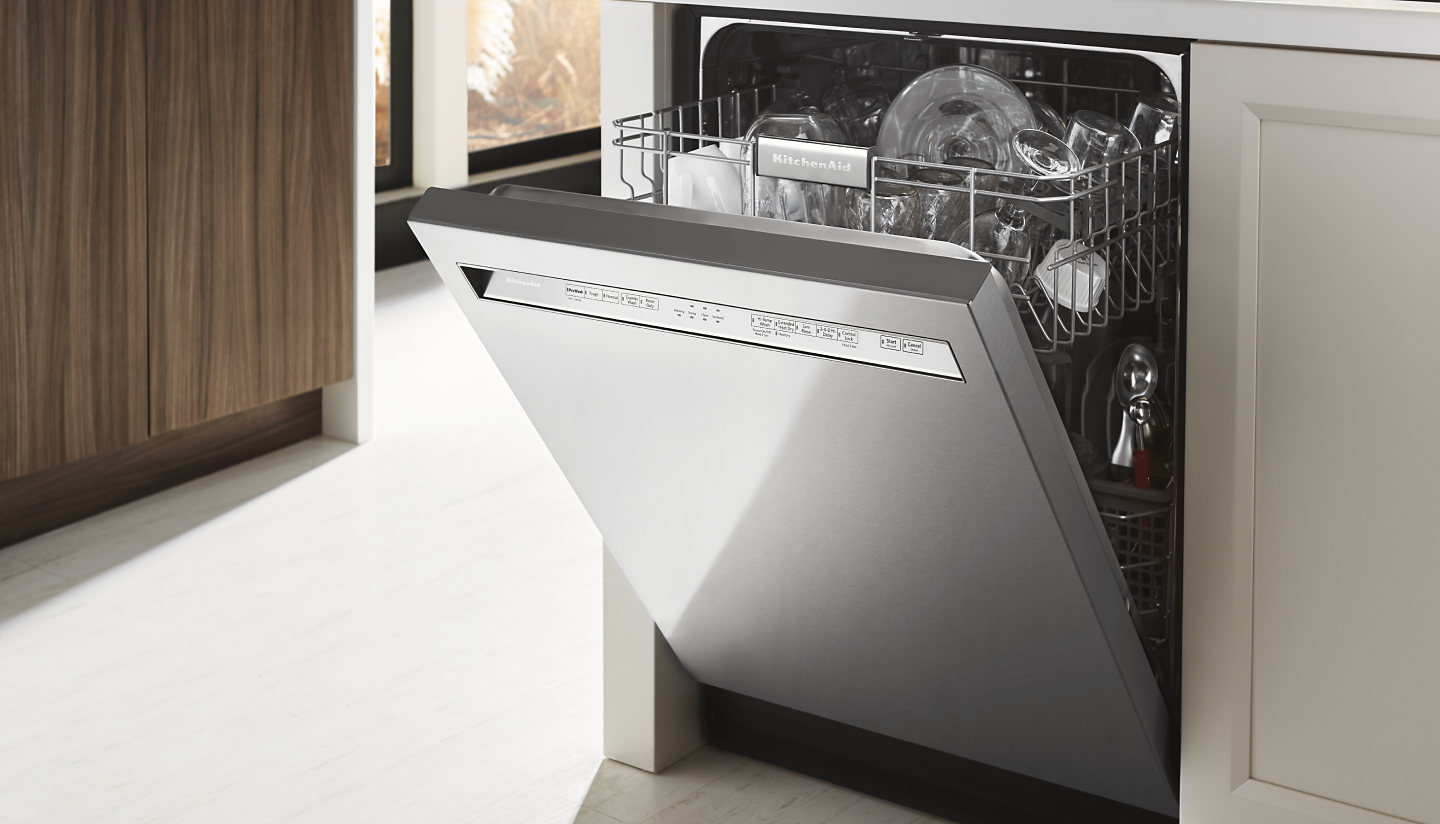 An open KitchenAid® dishwasher in a modern kitchen