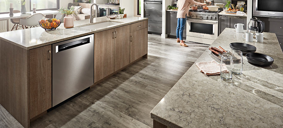 Stainless steel, KitchenAid® dishwasher in light brown cabinetry. 