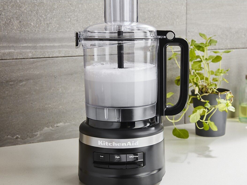 A frothy white liquid in a KitchenAid® food processor