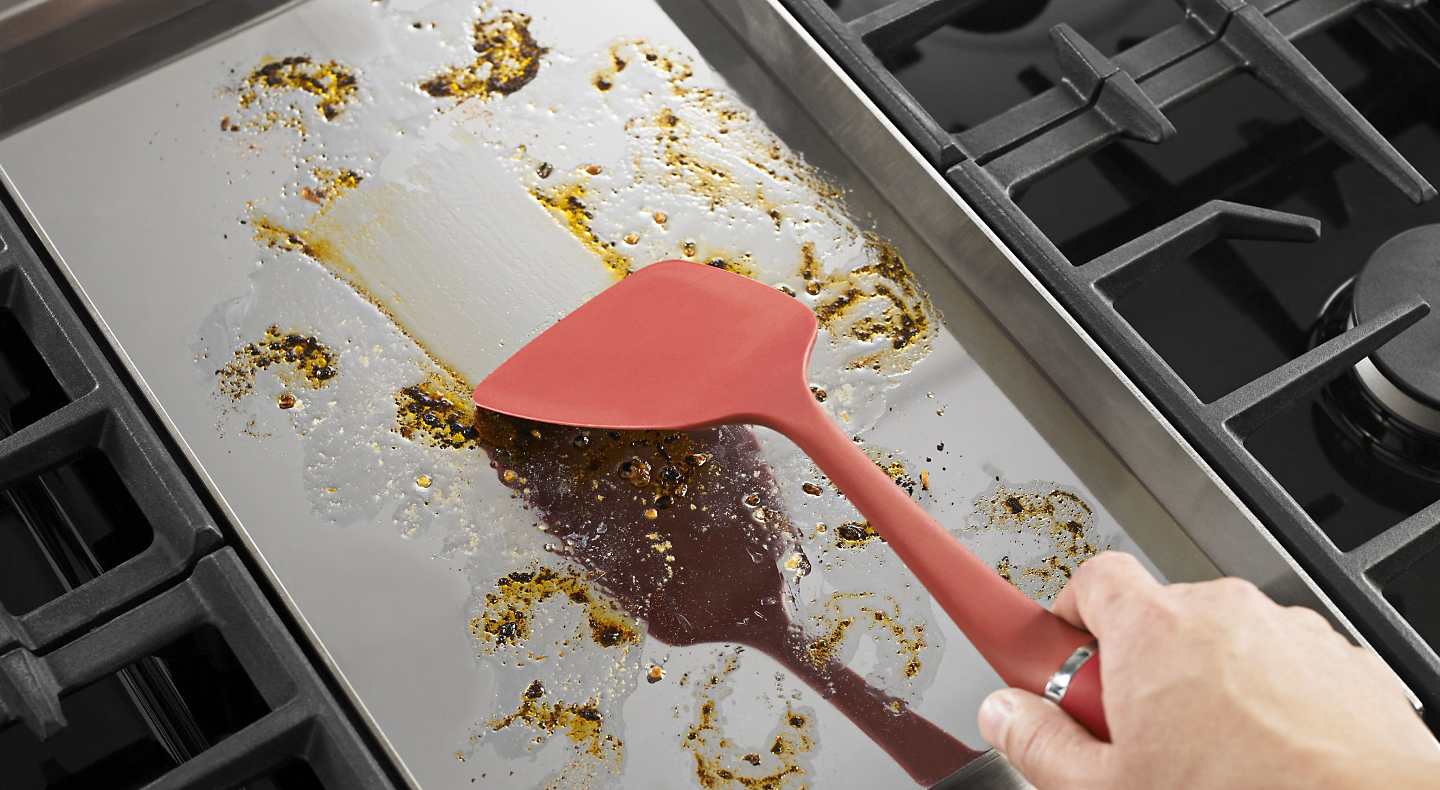 Person spreading grease with a spatula