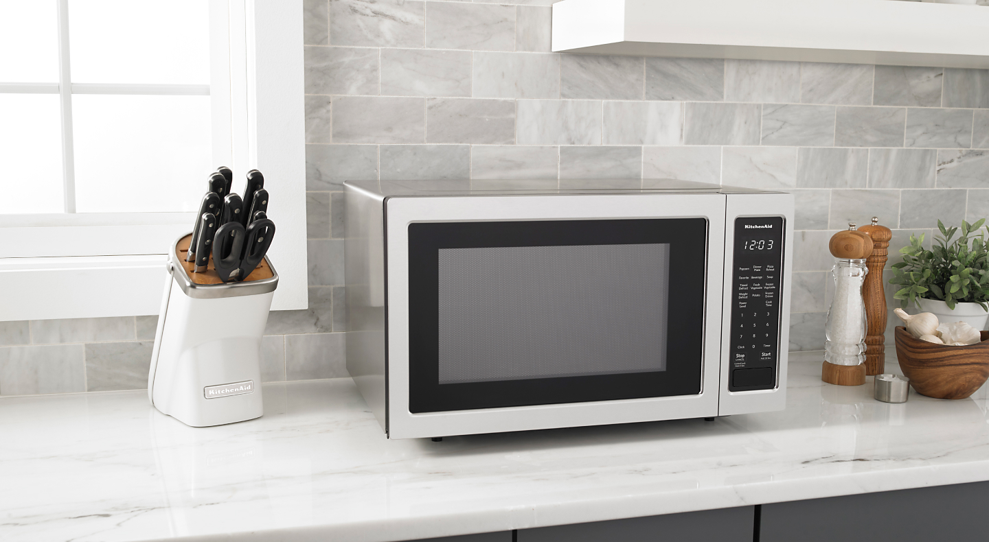 Stainless steel countertop microwave on a white counter